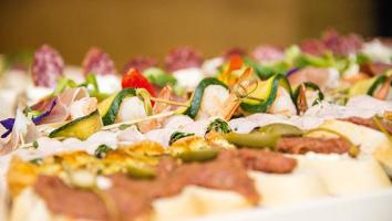 Varietà di panini guarniti con salumi, formaggi, verdure e decorazioni colorate.
