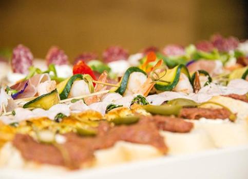 Colorful selection of topped bread rolls with cold cuts, cheese, vegetables, and decorative garnishes.
