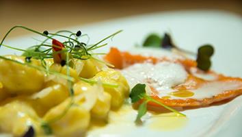Gnocchi mit gelber Sauce und rote Ravioli mit Schaum, garniert mit Sprossen