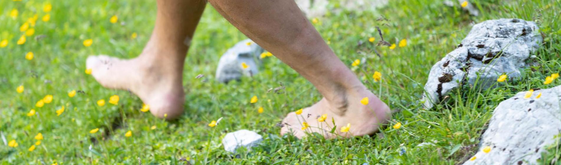 A person is walking barefoot on grass