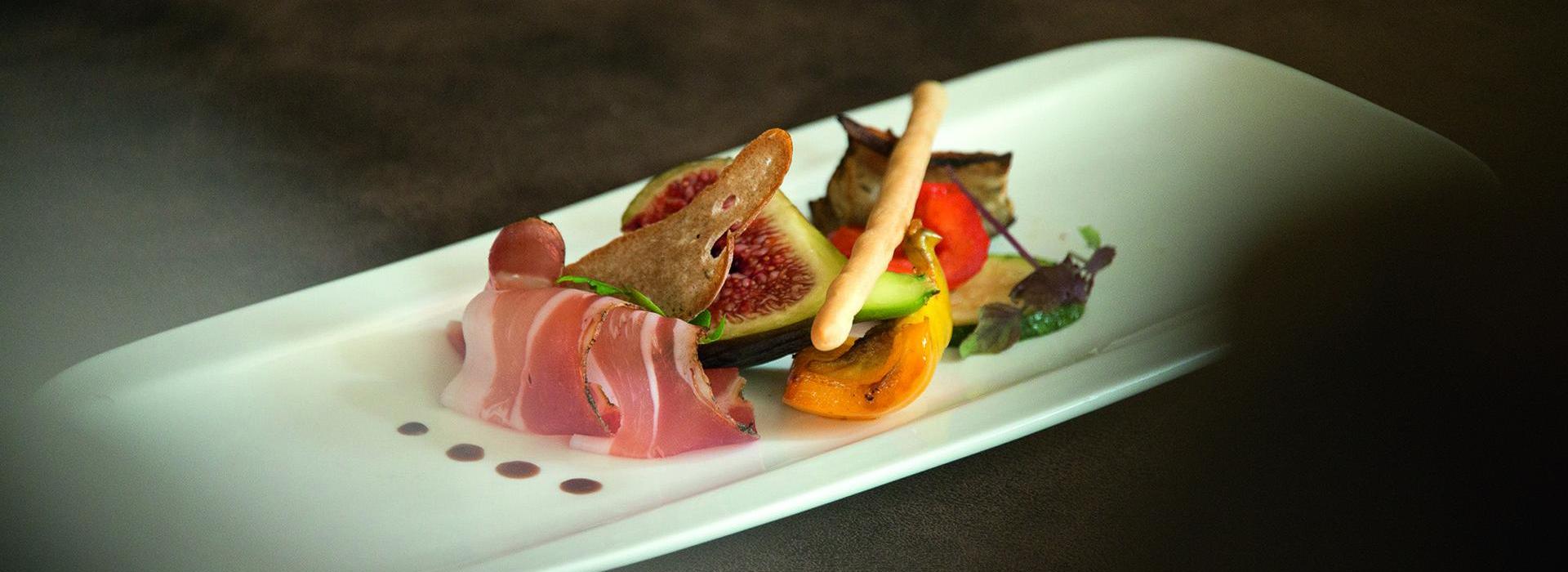 Antipasto con fico, speck, verdure grigliate e grissino