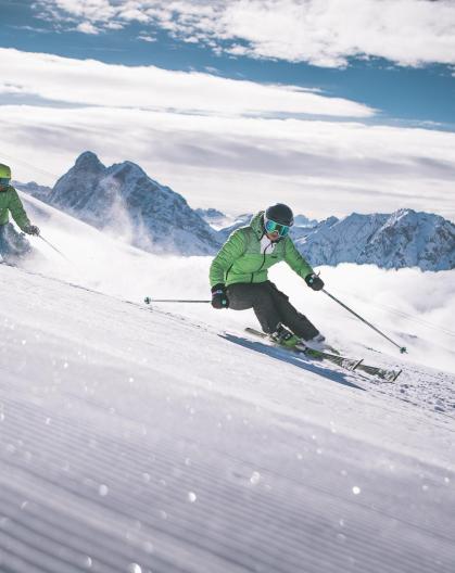 Two men are discending a ski slope