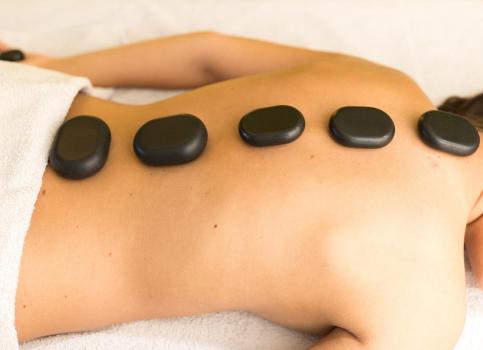 A woman is receiving a hot stone massage