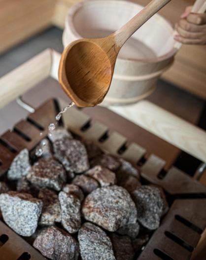 Someone is sprinkling water on the hot stones of the sauna