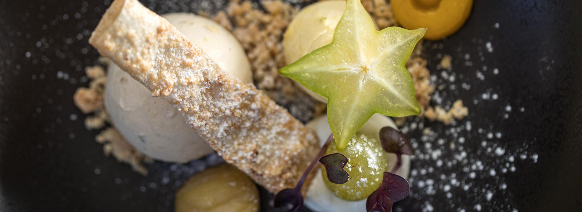 Dessert raffinato con gelato, carambola, crumble e creme