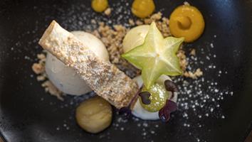 Dessert raffinato con gelato, carambola, crumble e creme