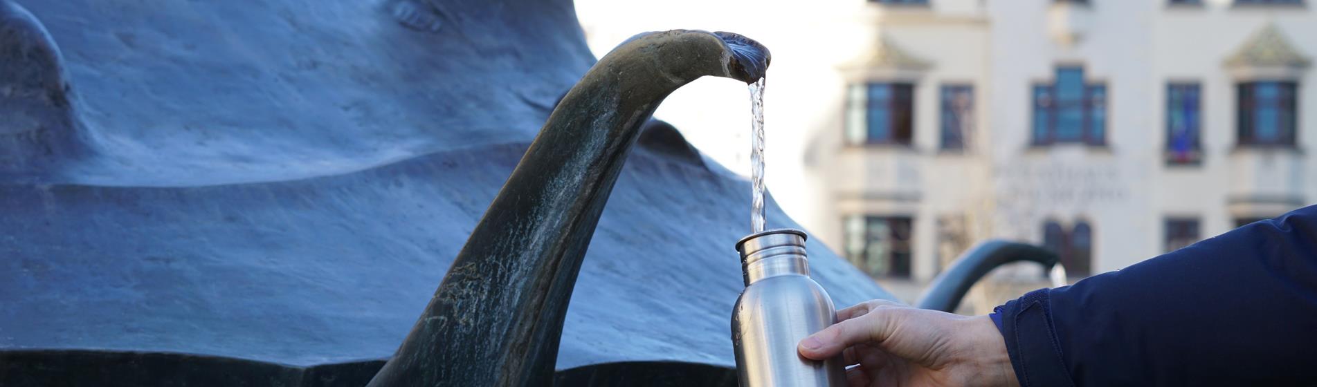Una persona riempie la propria boraccia alla fontana in piazza Duomo
