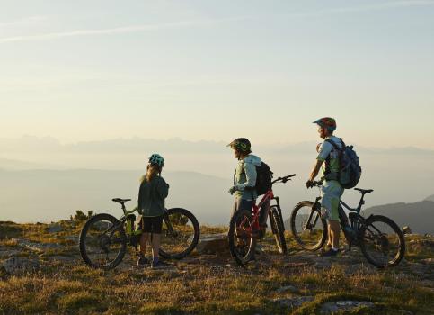 Three bikers enjoy the view from a mountain