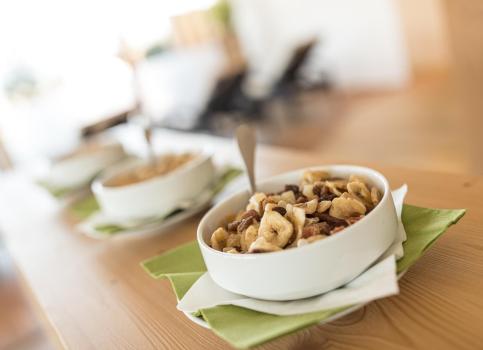 Ciotola con muesli e frutta secca su un tavolo di legno apparecchiato nella zona benessere.